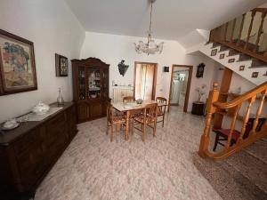 uma sala de jantar com mesa, cadeiras e escadas em Casa Anna em Pomarico