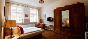 Schlafzimmer mit einem Bett, einer Kommode und einem Spiegel in der Unterkunft Schloss-und Seeblick Apartment in Rheinsberg