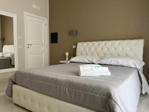 a large white bed with two towels on it at Pompei via Roma Suite in Pompei