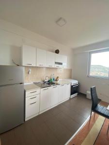 a kitchen with white appliances and a table and a window at City View Condominium in Skopje