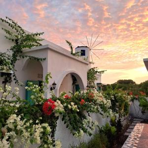 un edificio blanco con flores y un molino de viento en Anjo Maumere Hotel & Restaurant, en Nangalima