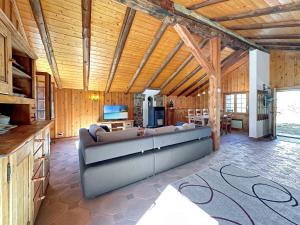a living room with a large couch in a room with wooden ceilings at Chalet le Basset - Keys to Paradise in the Alps in La Fouly