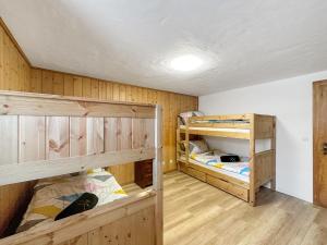 two bunk beds in a room with wooden walls at Chalet le Basset - Keys to Paradise in the Alps in La Fouly