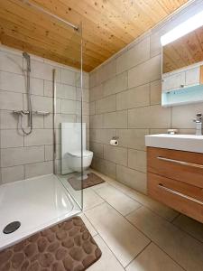 een badkamer met een douche, een toilet en een wastafel bij Chalet le Basset - Keys to Paradise in the Alps in La Fouly