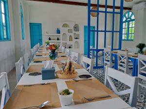 a dining room with long tables and white chairs at Anjo Maumere Hotel & Restaurant in Nangalima