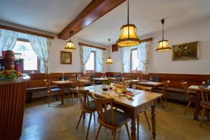 un restaurante con mesas de madera, sillas y luces en Gasthof Lamm, en Sankt Jodok am Brenner