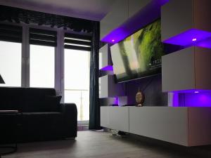 a living room with a couch and a large screen tv at Apartament Wolin z Widokiem Na Rzekę Dziwną - Valhalla Apart in Wolin