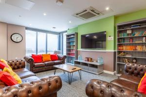 a living room with two couches and a table at For Students Only City Living Modern Studios at Hannah Court in Sheffield in Sheffield