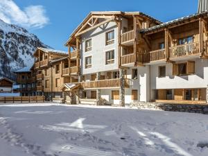a building in the snow with a parking lot at Appartement spacieux avec wifi, parking, balcon Sud à 10 min des commodités - FR-1-694-33 in Val dʼIsère