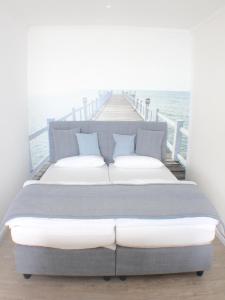 a bedroom with a large bed on a dock at Ferienwohnung Andreas Seeblick in Großenbrode