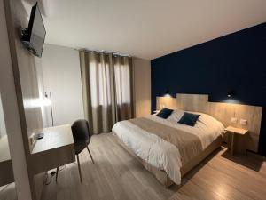 1 dormitorio con 1 cama grande y pared azul en Hôtel Restaurant Prunières, en Aumont-Aubrac
