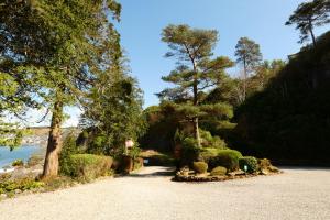 uma entrada de cascalho com arbustos e árvores numa colina em Dungallan Country House Bed & Breakfast em Oban