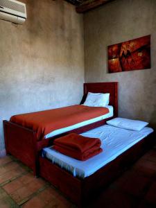 two twin beds in a bedroom with a painting on the wall at Riad Ain Khadra in Taroudant