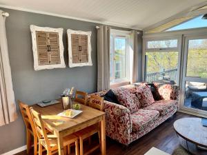 a living room with a couch and a table at Brackenrigg Lodge in Felton +13 photos
