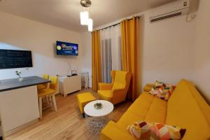 - un salon avec un canapé, une table et des chaises dans l'établissement Lijepo uređen stan u centru grada, à Knin