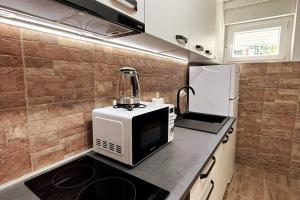 een keuken met een magnetron en een koelkast bij Lijepo uređen stan u centru grada in Knin