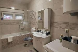 een badkamer met een wastafel, een toilet en een bad bij Lijepo uređen stan u centru grada in Knin +10 foto's