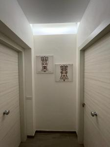 korytarz z dwoma drzwiami i dwoma zdjęciami na ścianie w obiekcie Dal Barone Rooms w mieście Salemi
