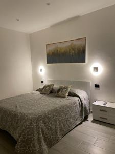 sypialnia z łóżkiem i obrazem na ścianie w obiekcie Dal Barone Rooms w mieście Salemi