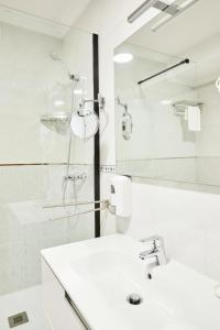 a white bathroom with a sink and a shower at Padrón Suites in Padrón +54 photos