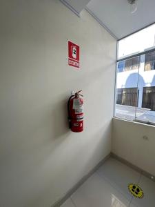 una boca de incendios en la pared de una habitación con ventana en Hostal Trumarka, en Cajamarca