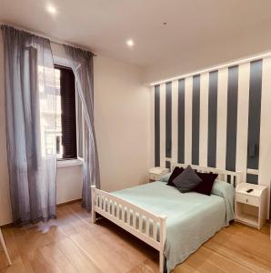 1 dormitorio con cama y pared a rayas en La Titina Sella en Bari