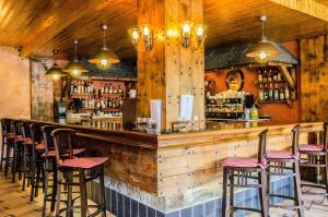 un bar avec une rangée de tabourets dans un restaurant dans l'établissement Hotel Coma, à Ordino