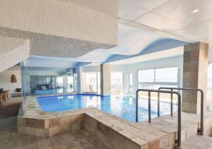 a large swimming pool in a large building at Diaz Ocean View Hotel in Mossel Bay