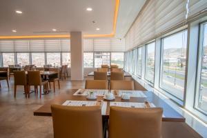 a restaurant with tables and chairs and windows at Parwar Hotel in Duhok