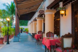 un restaurante con mesas y sillas en un edificio en Mizingani Seafront Hotel en Zanzíbar