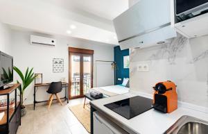 eine Küche und ein Wohnzimmer mit einem Sofa und einem Bett in der Unterkunft Oleti Studio Granada in Granada