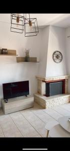 a living room with a fireplace and a tv at Dandelion Afytos in Afitos