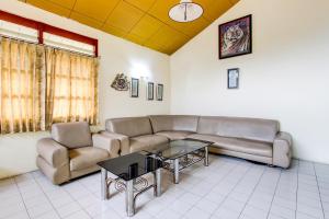een woonkamer met een bank en een tafel bij OYO 92505 Asta Guesthouse in Yogyakarta