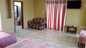 uma sala de estar com um sofá e uma cadeira em Hotel La Aldea em Atacames