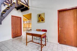 een tafel en stoelen in een kamer met een deur bij OYO 92505 Asta Guesthouse in Yogyakarta