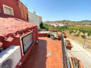 un balcón de una casa roja con techo rojo en Vivienda de estilo rústico con piscina LA GRANÁ, en Bullas