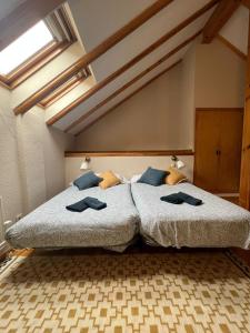 Un dormitorio con una cama grande con almohadas azules. en Arriel 28:24, en Escarrilla