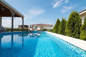 a swimming pool with blue water in a house at Villa Shelly whith private pool in Lozenets