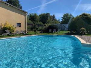 a large swimming pool with blue water in a yard at Gite du Facteur in Lens-Lestang