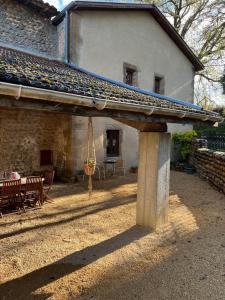 a stone house with a porch with a swing at Gite du Facteur in Lens-Lestang