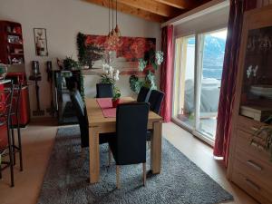 a dining room with a table and chairs and a window at Les balcons du Rhône in Daillon