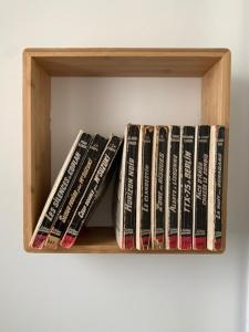 a row of dvds sitting on a shelf at Chambre d'Hôtes Les Petits Oiseaux in Nantes