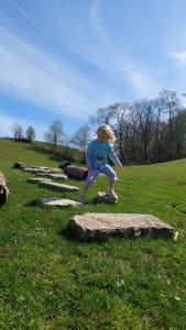 a little girl standing on rocks in a field at Sheepinn hoekje in Tielt