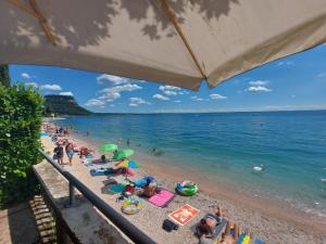 a group of people laying on a beach at Il nido di Agnese in Garda