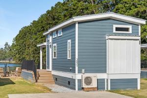 a blue and white tiny house with a porch at Sun Outdoors New Orleans North Shore in Robert