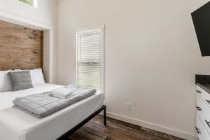 a white bedroom with a bed and a window at Sun Outdoors New Orleans North Shore in Robert +3 photos