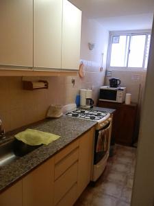 a small kitchen with a stove and a sink at Excelente monoambiente completo, funcional y muy cómodo - Zona "Aldrey" in Mar del Plata