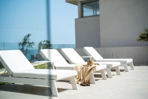 un grupo de sillas blancas sentadas en un patio en Villa Palm Beach - Incredible villa with 5 rooms, amazing sea view and private pool en Fuengirola