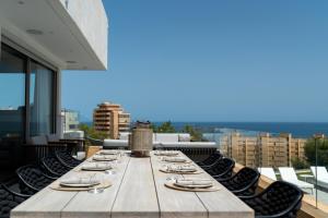 einem langen Holztisch auf dem Dach eines Gebäudes in der Unterkunft Villa Palm Beach - Incredible villa with 5 rooms, amazing sea view and private pool in Fuengirola