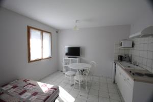 a small white kitchen with a table and a window at Lac et Montagne in Faverges